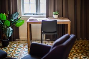 a desk with a chair in a room with a window at Boutique Hotel 't Klooster in Willemstad