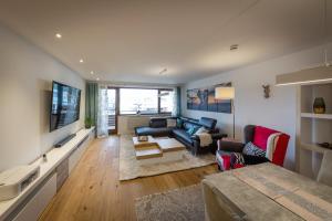 a living room with a blue couch and a tv at Premium Business Apartment Oberkochen Zentrum in Oberkochen