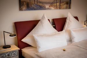 a bedroom with a bed with white pillows on it at Premium Business Apartment Oberkochen Zentrum in Oberkochen