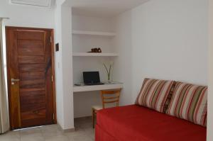 sala de estar con sofá y escritorio con ordenador portátil en Corzuelas Aparts - Mina Clavero en Mina Clavero