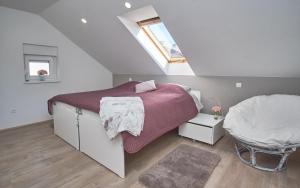 een slaapkamer op zolder met een bed en een raam bij Apartman Rafi in Čakovec +42 foto's