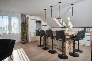 a kitchen with a table and black chairs in a room at Apartman Rafi in Čakovec