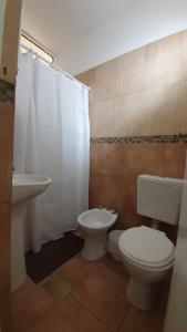 a bathroom with a white toilet and a sink at Pachá Anexo Rooms in Salta +16 photos