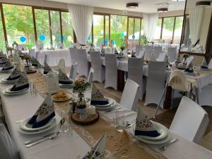 a banquet hall with white tables and white chairs at Mlyn Penzion & Wellness in Radvaň nad Dunajom