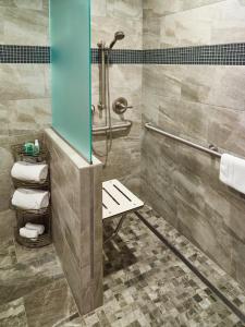 a bathroom with a shower with a bench and towels at LivINN Hotel St Paul East / Maplewood in Maplewood