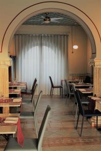 a dining room with tables and chairs and a window at Hotel Medusa in Lampedusa