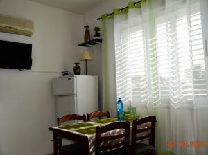 a kitchen with a table and a refrigerator and a window at Enjoy the silence apartments in Paphos