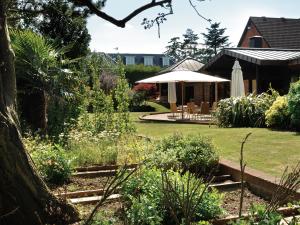 um jardim com um guarda-sol e uma casa em Fredrick's Hotel Restaurant Spa em Maidenhead