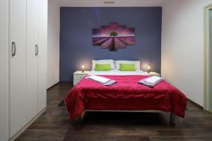 a bedroom with a large bed with a red blanket at Retreat in Rijeka