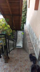 una escalera que conduce a un edificio con zapatos en el suelo en Prenoćište Dika, en Višegrad