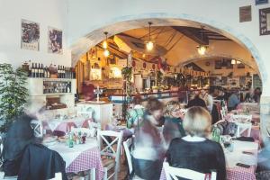a group of people sitting at tables in a restaurant at Retreat in Rijeka