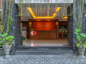 una puerta de entrada de una tienda con una señal roja en Grand Mirah Boutique Hotel en Denpasar