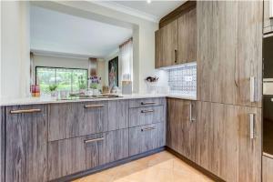 a large kitchen with wooden cabinets and a window at 2bedroom bungalow on Gramacho Golf Resort heated shared pool in Carvoeiro
