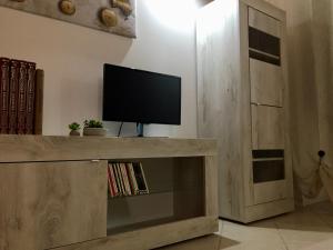 a television on a wooden entertainment center in a living room at Le Déjà Vue in Città di Castello
