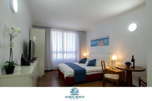 - une chambre avec un lit, une table et une télévision dans l'établissement Almog Haifa Israel Apartments מגדלי חוף הכרמל, à Haïfa