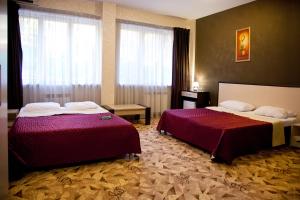 a hotel room with two beds and a window at Utomlyonnye Solntsem Hotel in Krasnaya Polyana