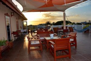 an outdoor patio with tables and chairs and an umbrella at Belizean Nirvana in Placencia