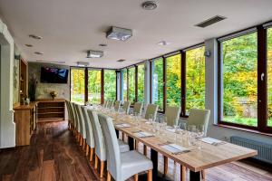 una lunga sala da pranzo con un lungo tavolo e sedie di Penzion a restaurace Bílý Mlýn a Liberec