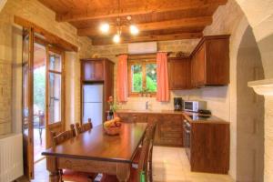 a kitchen with a wooden table and a dining room at Villa Phaedra in Prinés