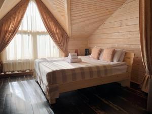リヴィウにあるVilla Kaiserの木製の部屋に大型ベッドが備わるベッドルーム1室が備わります。