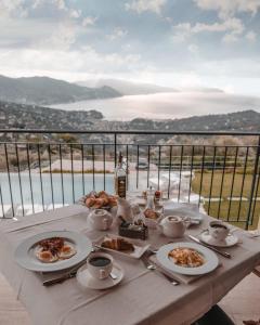 a table with plates of food and cups of coffee at Il Leccio - Luxury Resort Portofino Monte in Santa Margherita Ligure