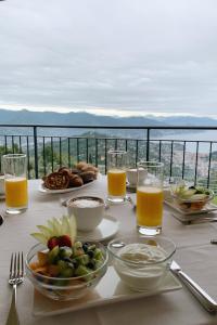 a table with plates of food and glasses of orange juice at Il Leccio - Luxury Resort Portofino Monte in Santa Margherita Ligure