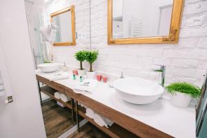 a white bathroom with two sinks and a mirror at Apartamenty Schoeps Residence in Poznań