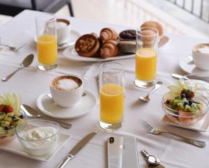 a white table with breakfast foods and orange juice at Il Leccio - Luxury Resort Portofino Monte in Santa Margherita Ligure