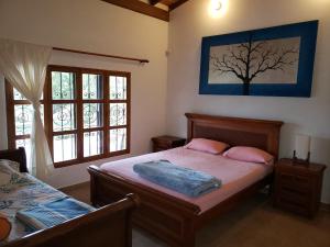 a bedroom with a bed and a tree painting on the wall at Beautiful Lake View Villa. Lake Access & Near Town in Guatapé