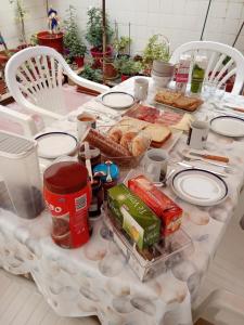 una mesa con comida y sillas blancas en Como en casa, en Alicante