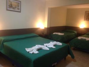 Dos camas en una habitación de hotel con toallas. en Hotel Pachá Anexo en Salta