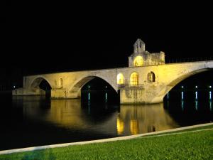 a large stone bridge over water at night at AU COEUR DES LICES *** CENTRE HISTORIQUE AVIGNON in Avignon