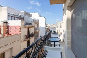 a balcony with a table and chairs on a building at Gianni Holiday Home in Pieta