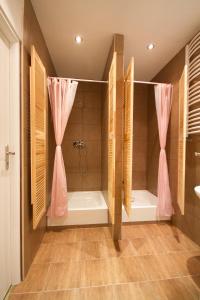 ein Badezimmer mit einer Badewanne und einer Dusche mit rosa Vorhängen in der Unterkunft 3 Bros' Hostel Cieszyn in Cieszyn