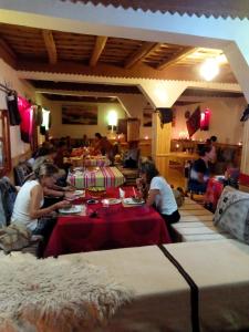 eine Gruppe von Personen, die an Tischen in einem Raum sitzen in der Unterkunft Maison La Vallée Des Figues Dadès in Tamellalt