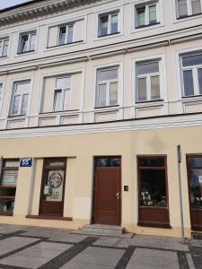 スヴァウキにあるSuwałki Centrum Apartments 1 & 2の茶色の扉が施された白い建物