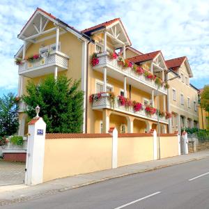 a large yellow building with flower boxes on the balconies at Pension Huber in Klosterneuburg