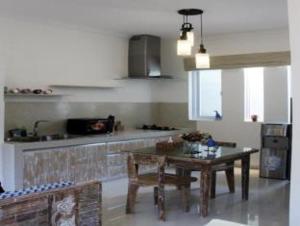 a kitchen with a wooden table and a kitchen counter at Green Studio Apartment Seminyak in Seminyak