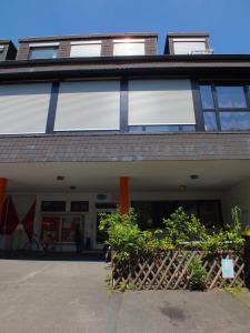 ein Gebäude mit Fenstern und Pflanzen davor in der Unterkunft Max Hostel in Bonn