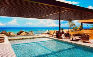 uma piscina com vista para o oceano em Singular Joy Downtown Residences em Playa del Carmen
