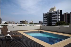 a swimming pool on the roof of a building at Golden Blue Hotel in Londrina