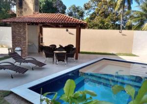 a patio with a table and chairs next to a pool at MAKAIBA RESIDENCE - FLATS DA Jô 001 in Baraúna
