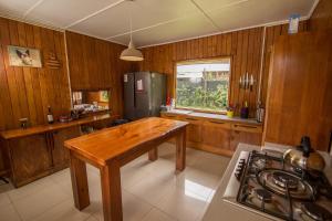 a kitchen with a wooden table and a refrigerator at Lucky's Hostel in Pucón