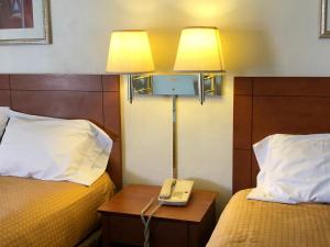 um quarto de hotel com duas camas e um telefone numa mesa em Economy Inn Alamogordo em Alamogordo