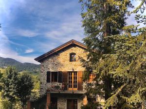 uma casa de pedra com uma varanda em cima em La Cappuccina em Corniglio