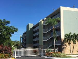 un edificio de apartamentos con una valla y palmeras en Days Inn by Wyndham Fort Lauderdale Airport Cruise Port en Fort Lauderdale