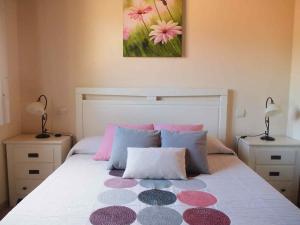 een slaapkamer met een bed met roze en paarse kussens bij LA CASA DE LAS AZAS in Casla +32 foto's