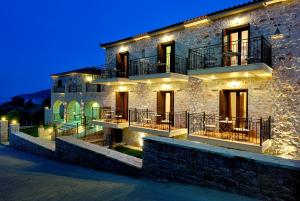 a stone house with lights on it at night at Byzantinon Hotel in Leonidio