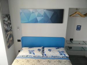 a bed with a blue headboard in a room at Larian Chalet in Moltrasio