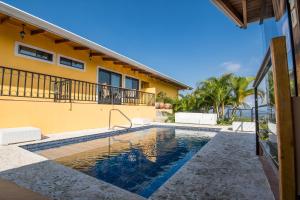 a swimming pool in front of a house at Barons Resort in Atenas